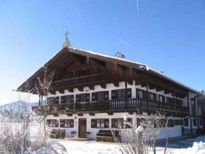 um grande edifício de madeira com neve em Gaestehaus Webermohof em Rottach-Egern