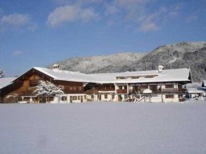 ein großes Gebäude mit einem schneebedeckten Dach in der Unterkunft Gästehaus Webermohof in Rottach-Egern