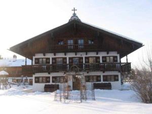 ein großes Gebäude mit Balkon im Schnee in der Unterkunft Gästehaus Webermohof in Rottach-Egern