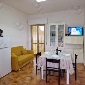 sala de estar con mesa y sofá amarillo en Mamma Mia, en Marina di Ginosa