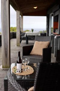 a bottle of wine sitting on a table with glasses at Casas Goulart in Canto da Areia
