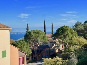 Blick auf eine Stadt mit Bäumen und Wasser in der Unterkunft Appartement Les Lauriers in Cavalaire-sur-Mer