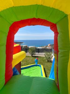 une maison gonflable colorée avec l'océan en arrière-plan dans l'établissement Villa Larissa, à Dolac