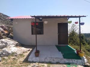 a small white house with a red roof at Silver Dew Resorts and Restaurant in Dhanaulti