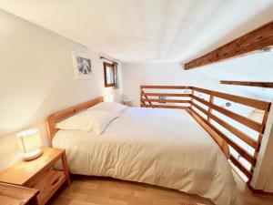 ein Schlafzimmer mit einem weißen Bett und einem Holzgeländer in der Unterkunft Appartement Les Lauriers in Cavalaire-sur-Mer