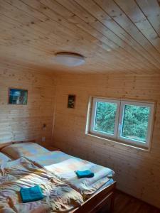 a bedroom with a bed in a wooden room at Penzion Pohoda in Jetřichovice