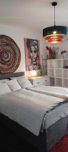um quarto com uma cama grande e uma pintura na parede em Apartmani Sollei em Petrcane