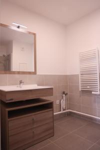 y baño con lavabo y espejo. en Résidence services seniors CAZAM Pontoise, en Pontoise