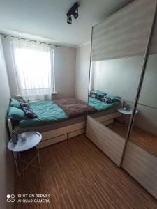 um pequeno quarto com uma cama e um espelho em Apartament boBoski em Wadowice