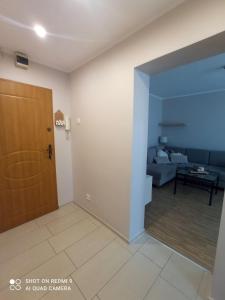 uma sala de estar com uma porta e um sofá em Apartament boBoski em Wadowice