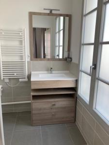 y baño con lavabo y espejo. en Résidence services seniors CAZAM Pontoise, en Pontoise