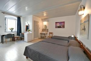 a bedroom with a bed and a dining room at Delfini Hotel in Hydra