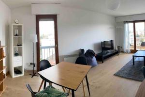 a living room with a table and chairs and a television at Vaste et lumineux T2 in Annemasse