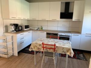 uma cozinha com armários brancos e uma mesa com duas cadeiras em Monteurzimmer/ Ferienwohnung Kati em Albstadt