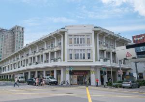a large white building on a city street with cars at hovoh homes Bugis Rochor in Singapore