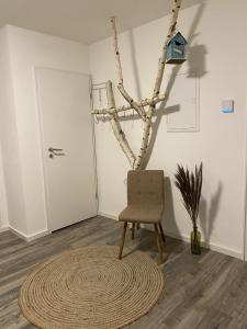 una silla y una alfombra en una habitación con un árbol en Apartment Heinrich Zille, en Grimma