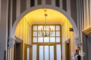 an archway over a door with a chandelier above it at Burlington House in Oxford