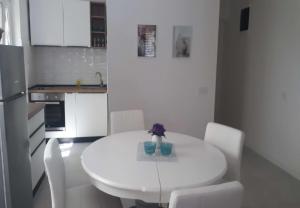 uma cozinha branca com uma mesa branca e cadeiras brancas em Summer House Bella on the Beach em Podaca