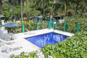 a swimming pool with chairs and an umbrella at Alapage Toque Toque in Toque Toque Pequeno