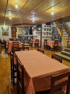 a dining room with tables and chairs and a kitchen at La Ramada de Mama Elena in Oxapampa