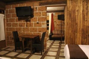 um quarto com uma mesa e uma televisão numa parede de tijolos em Hotel Real Nirvana em Tecozautla