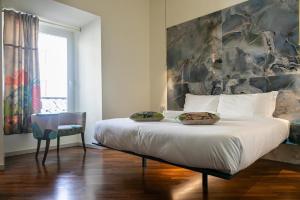 a bedroom with a large bed with two pillows on it at Bhr Cavour 150 in Rome