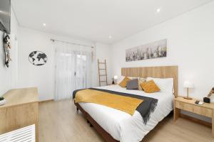 een slaapkamer met een groot wit bed met oranje kussens bij LUMO Apartment Fátima in Fátima