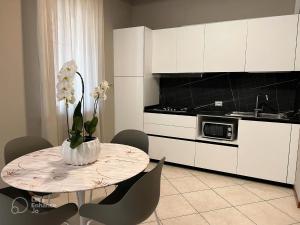 a kitchen with a table with a vase of flowers on it at Residenza Mediterranea Apartments in Rimini