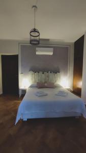 a bedroom with a large white bed with a light at Agriturismo Vallerana in Capalbio