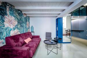 a living room with a purple couch and a table at Open Suite Cobalto in Cagliari