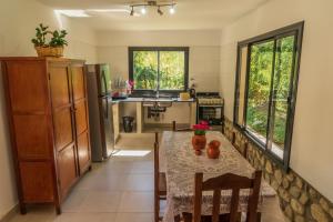 une cuisine avec une table et des chaises et une cuisine avec un évier dans l'établissement HOSPEDAJE LA CASONA DE CACHI, à Cachí