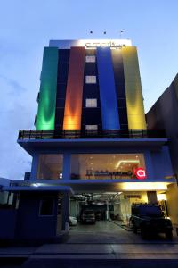 un edificio con coches estacionados en un estacionamiento en Amaris Hotel Panakkukang, en Makassar