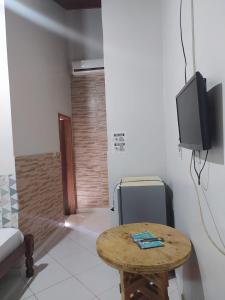 a room with a table and a tv in a room at Engenheiros Hotel - Porto Velho in Porto Velho