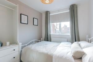 a bedroom with a white bed and a window at The Maltings in Shrewsbury