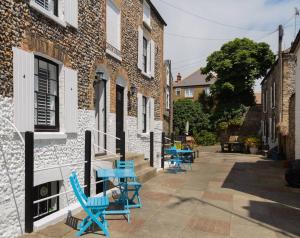 a group of blue chairs sitting outside of a building at Sandpiper Cottage By The Sea. Broadstairs. in Kent