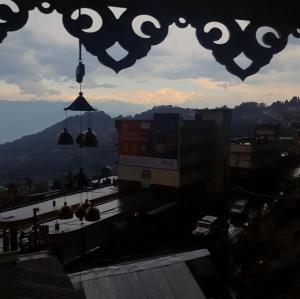 a view of a city from a window with bells at Neora Backpackers Hostel in Darjeeling