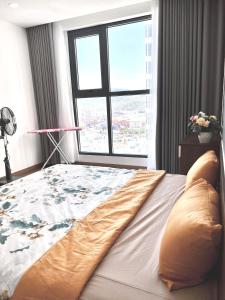 un letto in una camera con una grande finestra di BBnB Home RESIDENCE a Quy Nhon
