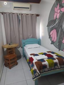 um quarto com uma cama azul e uma mesa em Engenheiros Hotel - Porto Velho em Porto Velho