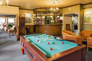 a pool table in a room with a bar at Family Hotel in Vic-sur-Cère