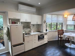 a kitchen with white cabinets and a table in it at Beletage in Knysna
