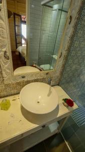 uma casa de banho com um lavatório branco e um espelho. em villa del sole lagoa em Jijoca de Jericoacoara