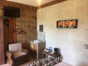 um quarto com uma cama, uma cadeira e uma televisão em Hotel Real Nirvana em Tecozautla