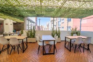 a room with tables and chairs and plants at ICON 48 Luxury Apartasuites in Bogotá