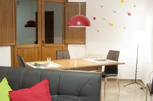 una sala da pranzo con tavolo, sedie e luci rosse di Apartamentos Catedral Plaza 3000 a Granada