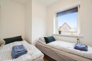 two beds in a room with a window at Delicius apartment near the Beach,Metro, Airport in Copenhagen