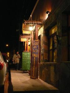 a building with signs on a street at night at La Casa del Tata in Maimará