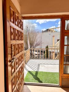 an open door with a view of a balcony at Zambala guest house in Leh