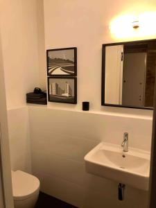 a bathroom with a sink and a toilet and a mirror at Stylisches Loft mitten in Berlin in Berlin