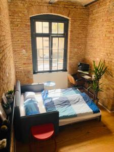 1 dormitorio con 1 cama en una pared de ladrillo en Stylisches Loft mitten in Berlin, en Berlín