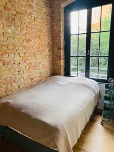 a bed in a room with a brick wall at Stylisches Loft mitten in Berlin in Berlin